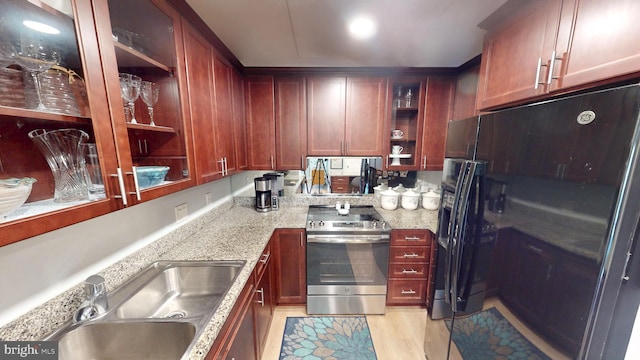 960 Fell St Unit 609, Baltimore, MD 21231 - kitchen featuring stainless steel electric range oven, open shelves, black refrigerator with ice dispenser, reddish brown cabinets, and light stone countertops
