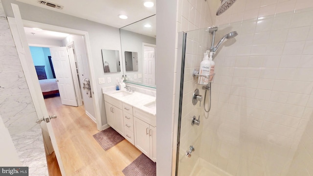 960 Fell St Unit 609, Baltimore, MD 21231 - ensuite bathroom with a tile shower, double vanity, wood finished floors, and recessed lighting