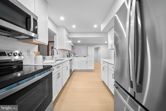 12779 Lost Creek Ct, Manassas, VA 20112 - kitchen featuring stainless steel appliances, light countertops, light wood finished floors, tasteful backsplash, and white cabinetry