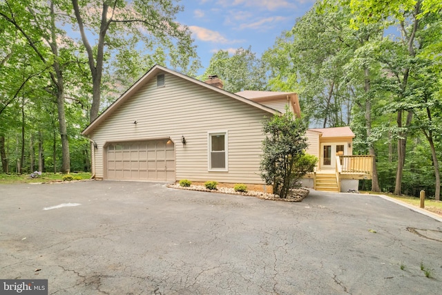12779 Lost Creek Ct, Manassas, VA 20112 - view of home's exterior with driveway, a deck, a chimney, and a garage