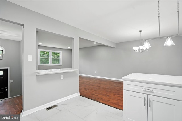 9884 Bird River Rd, Baltimore, MD 21220 - kitchen with light countertops, white cabinetry, a chandelier, decorative light fixtures, and recessed lighting