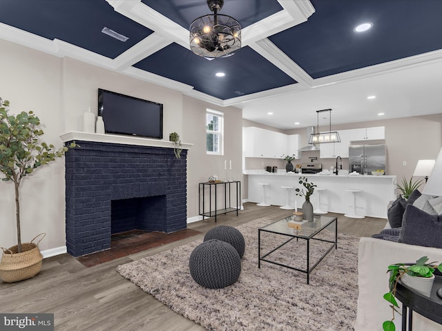 3708 Mohawk Ave, Baltimore, MD 21207 - living area with coffered ceiling, a chandelier, crown molding, wood finished floors, and a fireplace