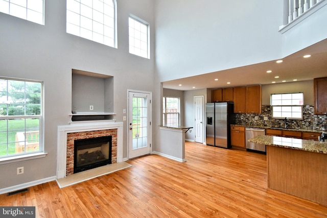 316 Wheatfield Cir, Hatfield, PA 19440 - kitchen featuring stainless steel appliances, light wood finished floors, a towering ceiling, open floor plan, and a fireplace