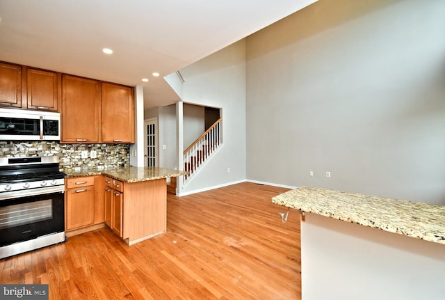 316 Wheatfield Cir, Hatfield, PA 19440 - kitchen with white microwave, stainless steel gas range, tasteful backsplash, light wood-style floors, and recessed lighting