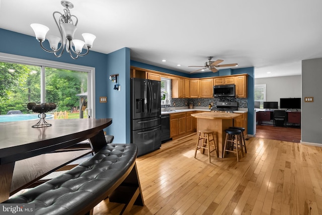 613 Main St, Langhorne, PA 19047 - kitchen with refrigerator with ice dispenser, stainless steel electric stove, black dishwasher, a chandelier, and decorative backsplash