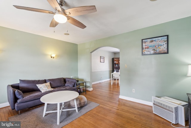 6604 Altamont Ave, Baltimore, MD 21228 - living room featuring arched walkways, hardwood / wood-style flooring, a ceiling fan, and a wall mounted air conditioner