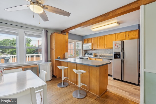 6604 Altamont Ave, Baltimore, MD 21228 - kitchen featuring stainless steel appliances, beamed ceiling, light wood-style flooring, backsplash, and a peninsula