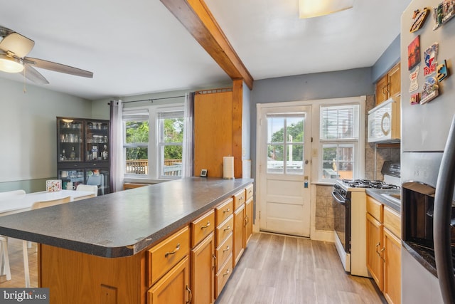 6604 Altamont Ave, Baltimore, MD 21228 - kitchen featuring white appliances, ceiling fan, a peninsula, and plenty of natural light