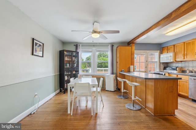 6604 Altamont Ave, Baltimore, MD 21228 - kitchen featuring white microwave, stove, healthy amount of natural light, a ceiling fan, and beamed ceiling