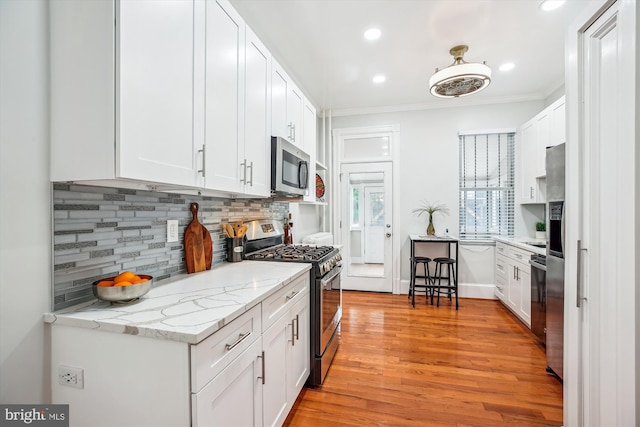 609 Elliott St NE, Washington, DC 20002 - kitchen featuring appliances with stainless steel finishes, backsplash, ornamental molding, white cabinets, and recessed lighting