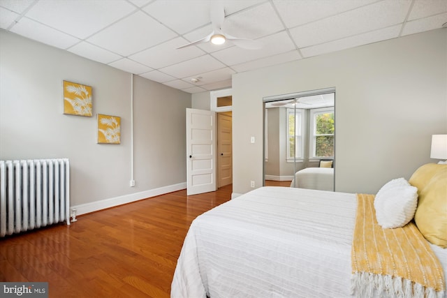 609 Elliott St NE, Washington, DC 20002 - bedroom with radiator, a drop ceiling, wood finished floors, a closet, and a ceiling fan