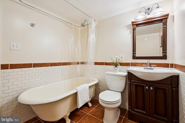 609 Elliott St NE, Washington, DC 20002 - full bath with tile walls, a freestanding bath, a wainscoted wall, tile patterned flooring, and vanity