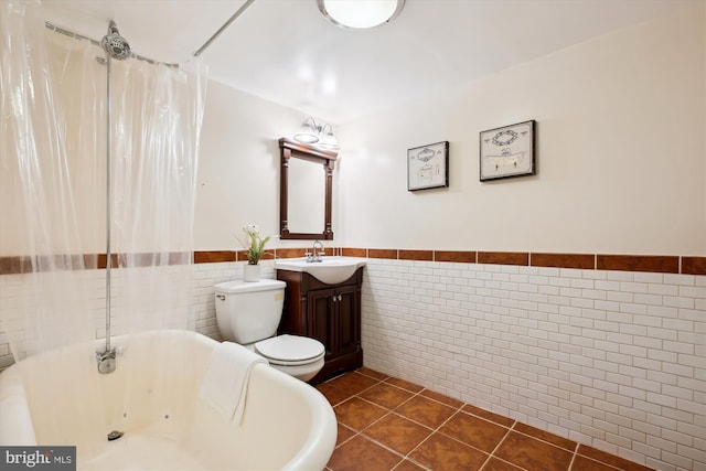 609 Elliott St NE, Washington, DC 20002 - full bath featuring a whirlpool tub, tile walls, vanity, tile patterned floors, and wainscoting