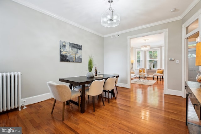609 Elliott St NE, Washington, DC 20002 - dining space with radiator, a chandelier, light wood finished floors, and crown molding