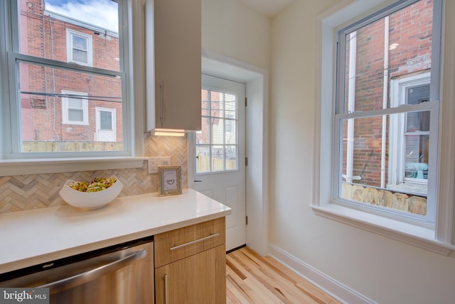 921 S Conestoga St, Philadelphia, PA 19143 - kitchen with dishwasher, tasteful backsplash, light countertops, and light wood-style flooring