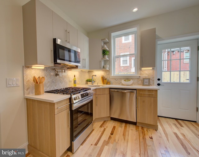 921 S Conestoga St, Philadelphia, PA 19143 - kitchen featuring appliances with stainless steel finishes, light countertops, light wood-style floors, backsplash, and recessed lighting