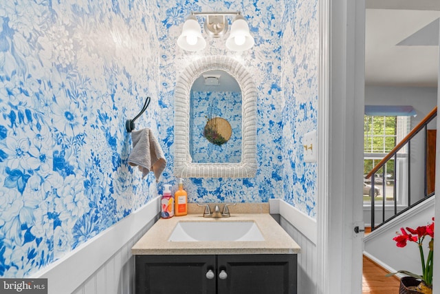 8857 Blade Green Ln, Columbia, MD 21045 - bathroom with wallpapered walls, vanity, a chandelier, and wood finished floors