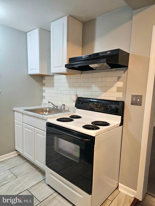 18 N 5th St, Columbia, PA 17512 - kitchen with white range with electric stovetop, white cabinets, wall chimney range hood, backsplash, and light countertops