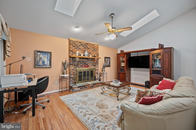 12330 Needlepine Ter, Silver Spring, MD 20904 - living area with a skylight, a ceiling fan, a fireplace, vaulted ceiling, and light wood-type flooring