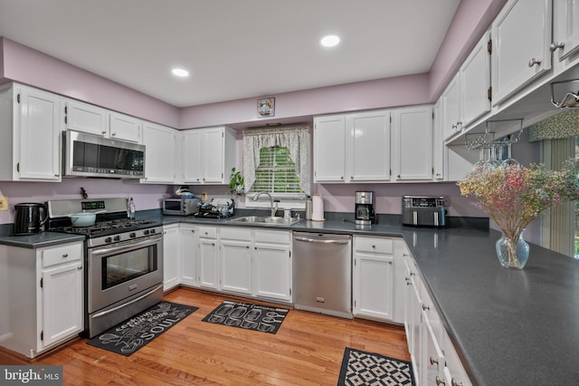 12330 Needlepine Ter, Silver Spring, MD 20904 - kitchen featuring stainless steel appliances, dark countertops, white cabinetry, light wood-type flooring, and recessed lighting