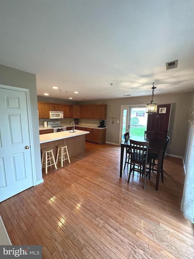 226 Prairie Ct, Quakertown, PA 18951 - kitchen with white appliances, light countertops, light wood-style flooring, recessed lighting, and brown cabinets