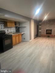 7128 Crestshire, Baltimore, MD 21222 - unfurnished living room with a brick fireplace and light wood-style floors