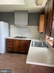 7128 Crestshire, Baltimore, MD 21222 - kitchen with freestanding refrigerator, light countertops, tasteful backsplash, and cooktop