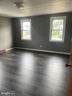 7128 Crestshire, Baltimore, MD 21222 - empty room featuring healthy amount of natural light and dark wood-style flooring