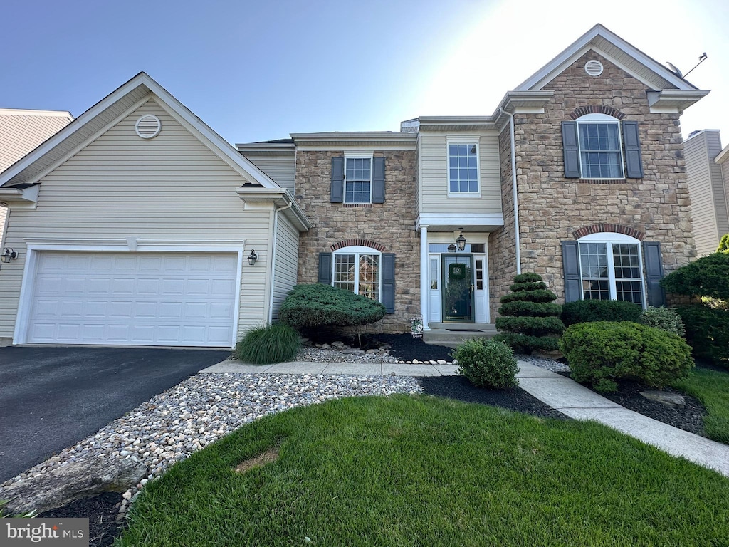 1989 Strathmore Dr, Macungie, PA 18062 - view of front of property with stone siding, asphalt driveway, a garage, and a front lawn