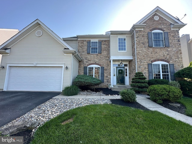 1989 Strathmore Dr, Macungie, PA 18062 - view of front of property with stone siding, asphalt driveway, a garage, and a front lawn