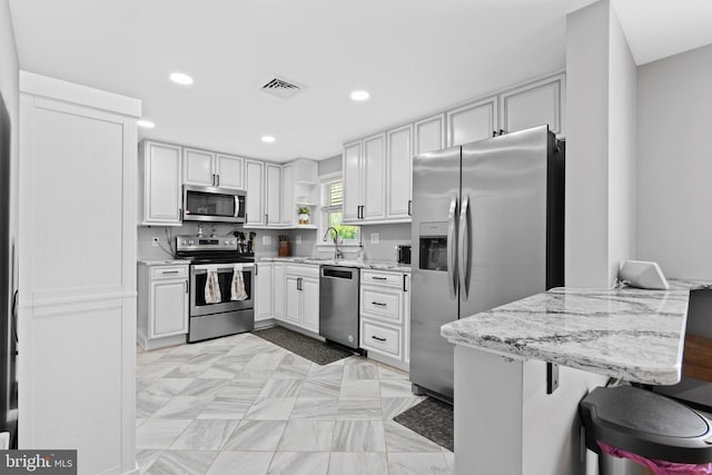 566 S Old Middletown Rd, Media, PA 19063 - kitchen with appliances with stainless steel finishes, recessed lighting, open shelves, light stone counters, and white cabinetry