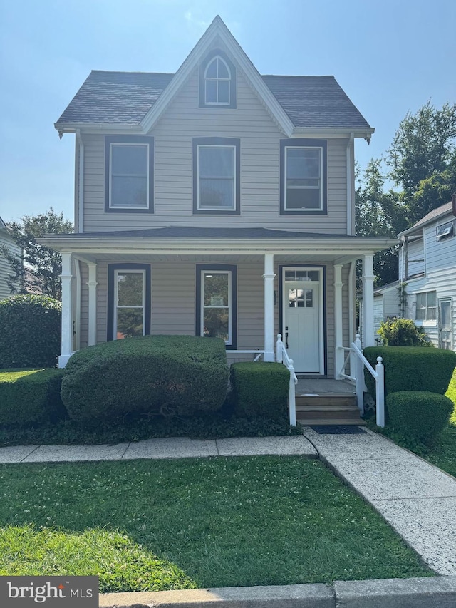 716 S Washington St, Havre De Grace, MD 21078 - view of front facade with covered porch, roof with shingles, and a front lawn