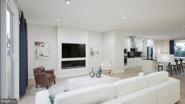 42227 Shining Star Sq, Ashburn, VA 20148 - living room featuring light wood finished floors, recessed lighting, and a glass covered fireplace