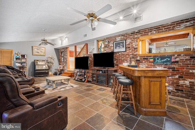 199 Cox Ave, West Creek, NJ 08092 - living room with a ceiling fan, a textured ceiling, a dry bar, vaulted ceiling, and brick wall