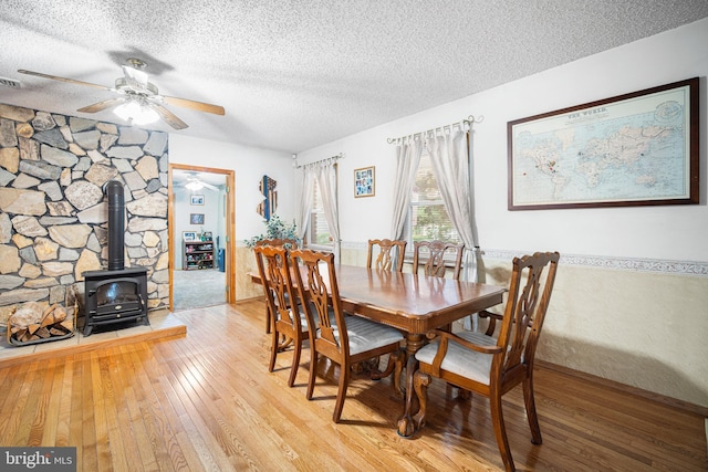 199 Cox Ave, West Creek, NJ 08092 - dining area featuring a ceiling fan, hardwood / wood-style floors, a wood stove, and a textured ceiling