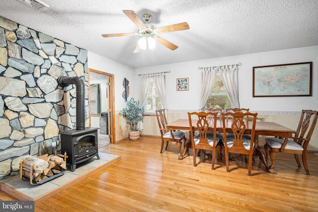 199 Cox Ave, West Creek, NJ 08092 - dining space with a textured ceiling, light wood-type flooring, a wood stove, and ceiling fan