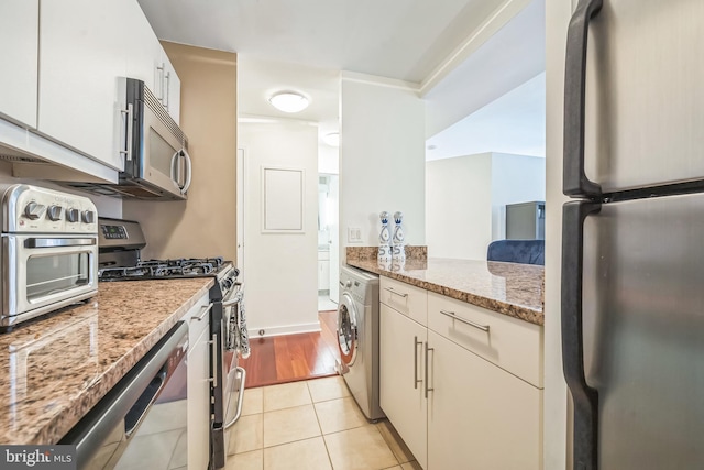 219 S 18th St Unit 1522, Philadelphia, PA 19103 - kitchen with stainless steel appliances, washer / dryer, light tile patterned flooring, and light stone counters
