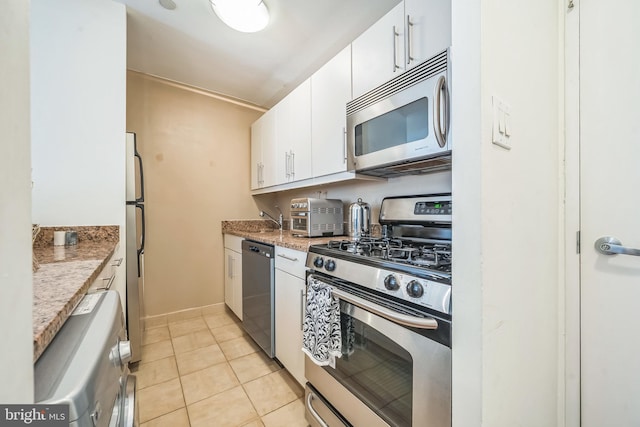 219 S 18th St Unit 1522, Philadelphia, PA 19103 - kitchen featuring appliances with stainless steel finishes, white cabinetry, light tile patterned flooring, and light stone countertops
