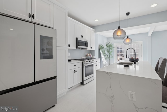 706 Longfellow St NW, Washington, DC 20011 - kitchen with stainless steel appliances, pendant lighting, white cabinets, recessed lighting, and a center island with sink