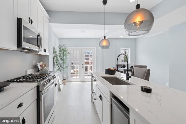 706 Longfellow St NW, Washington, DC 20011 - kitchen with stainless steel appliances, french doors, light stone counters, white cabinets, and recessed lighting