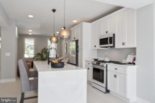 706 Longfellow St NW, Washington, DC 20011 - kitchen featuring stainless steel appliances, an island with sink, recessed lighting, white cabinetry, and a breakfast bar area