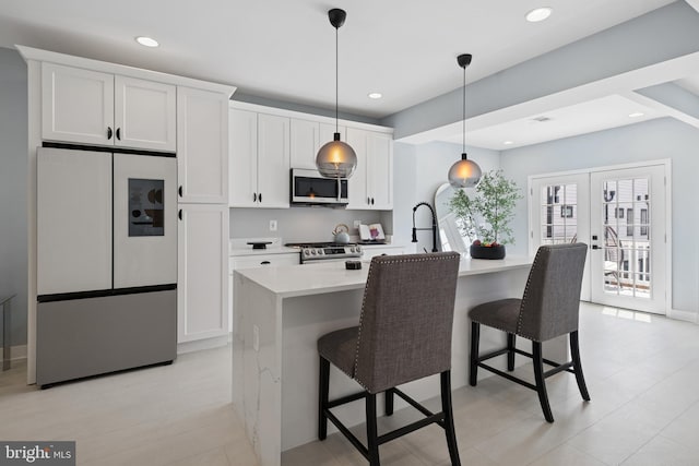 706 Longfellow St NW, Washington, DC 20011 - kitchen featuring stainless steel appliances, a breakfast bar area, an island with sink, white cabinets, and recessed lighting