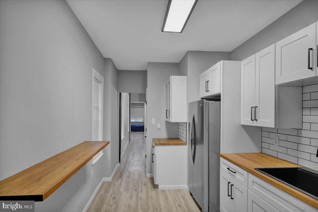 446 S 15th St, Reading, PA 19602 - kitchen featuring butcher block countertops, freestanding refrigerator, light wood finished floors, tasteful backsplash, and white cabinetry