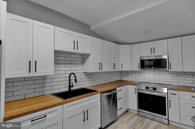 446 S 15th St, Reading, PA 19602 - kitchen featuring butcher block countertops, appliances with stainless steel finishes, white cabinets, and vaulted ceiling