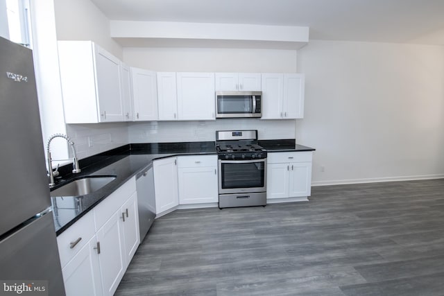1615 Rowan St, Philadelphia, PA 19140 - kitchen with appliances with stainless steel finishes, decorative backsplash, white cabinets, and wood finished floors