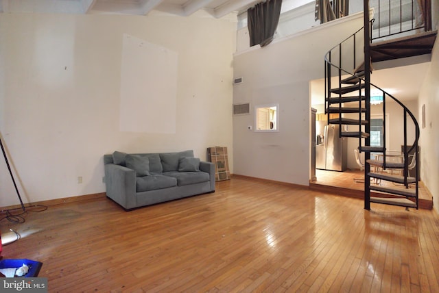20B Oscar Hammerstein Way Unit 20B, New Hope, PA 18938 - unfurnished living room with wood-type flooring, stairs, beamed ceiling, and a high ceiling