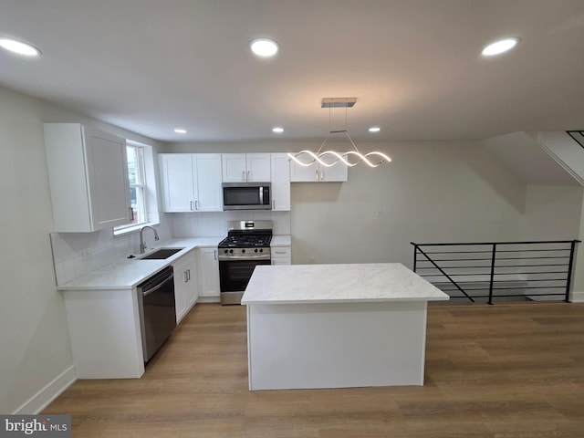 1473 Stevens St, Philadelphia, PA 19149 - kitchen featuring appliances with stainless steel finishes, white cabinets, a center island, tasteful backsplash, and hanging light fixtures