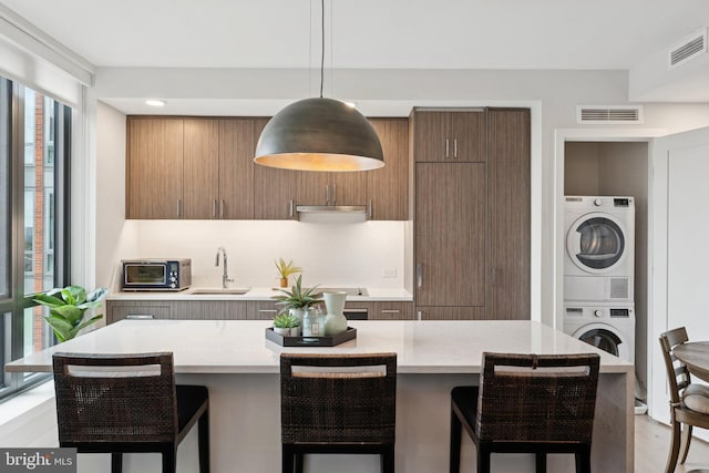 1211 Van St SE Unit 913, Washington, DC 20003 - kitchen featuring stacked washing machine and dryer, plenty of natural light, and light countertops