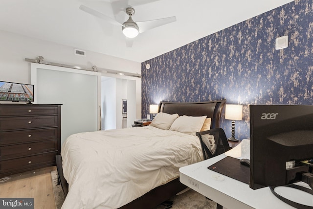 1211 Van St SE Unit 913, Washington, DC 20003 - bedroom with wallpapered walls, light wood finished floors, and ceiling fan
