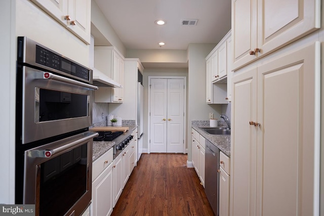 2801 Connecticut Ave NW Unit 32, Washington, DC 20008 - kitchen with stainless steel appliances, dark wood-style floors, white cabinetry, recessed lighting, and light stone countertops